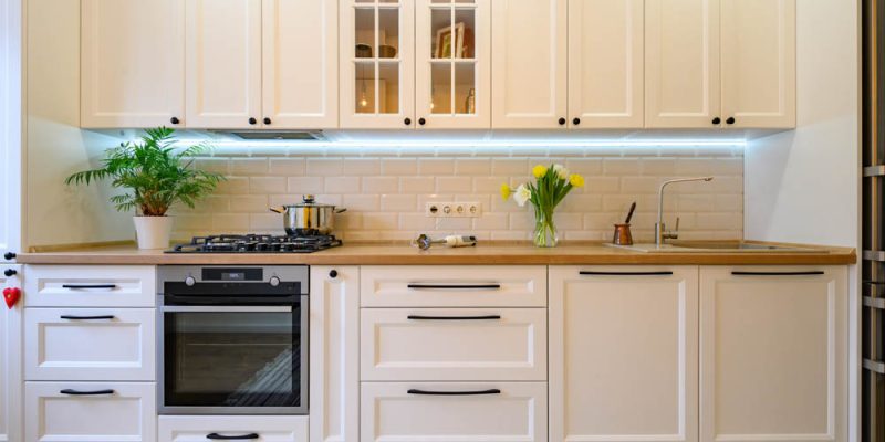 A warm and inviting kitchen space with white cabinetry, subway tile backsplash, and wooden countertops, complemented by modern appliances and natural light.